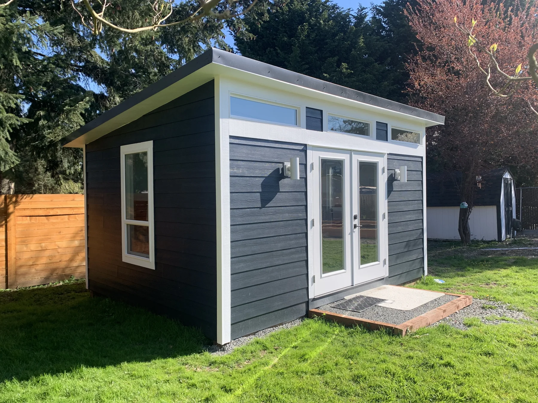 Finished detached backyard studio with modern windows and double doors