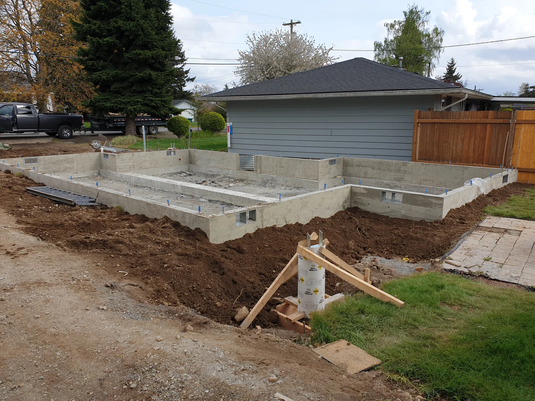 New poured concrete stem-wall foundation beside an existing garage