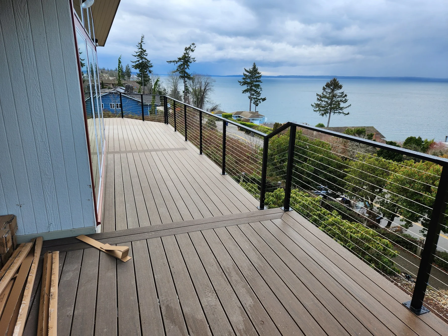 Composite deck with black cable railing overlooking Puget Sound